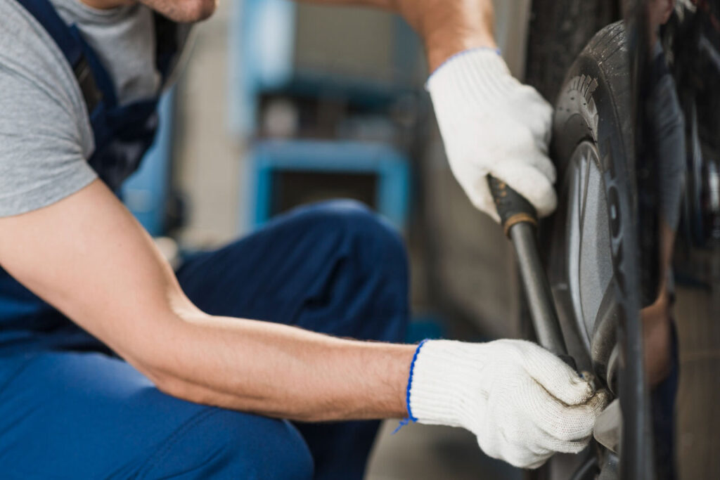 Mecânico utilizando ferramenta durante atividade mecânica.