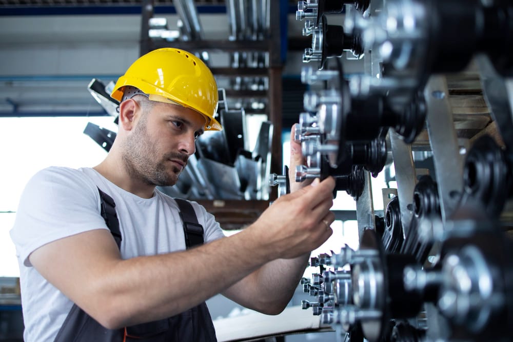 Técnico realizando manutenção industrial em equipamento com ajuste de componentes mecânicos.