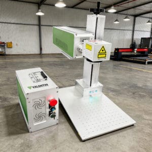 M&aacute;quina de grava&ccedil;&atilde;o a laser realizando corte de precis&atilde;o em chapa met&aacute;lica com fa&iacute;scas durante o processo industrial